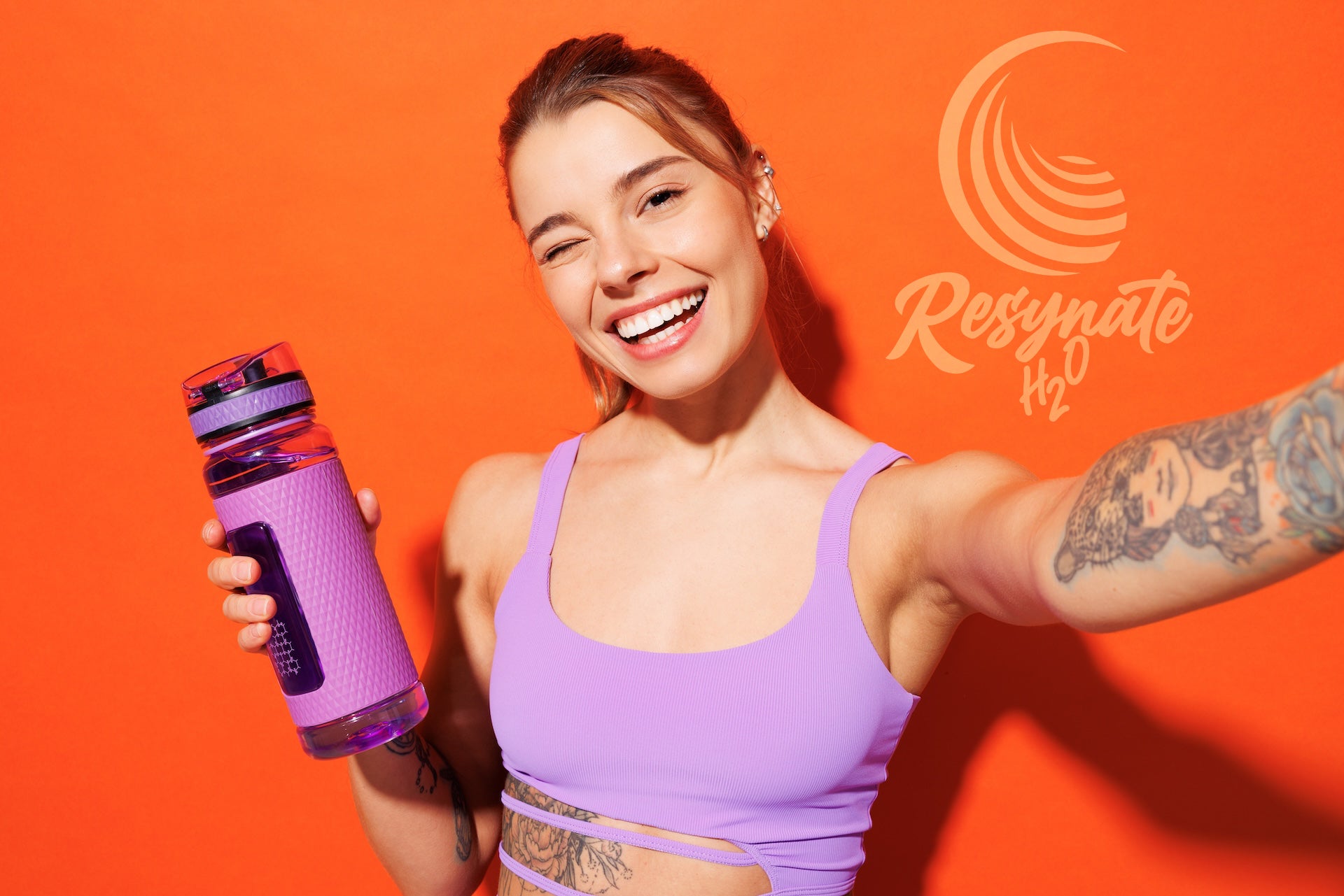 Athlete holding water bottle using Resynate H2O electrolyte powder for hydration, energy, and performance